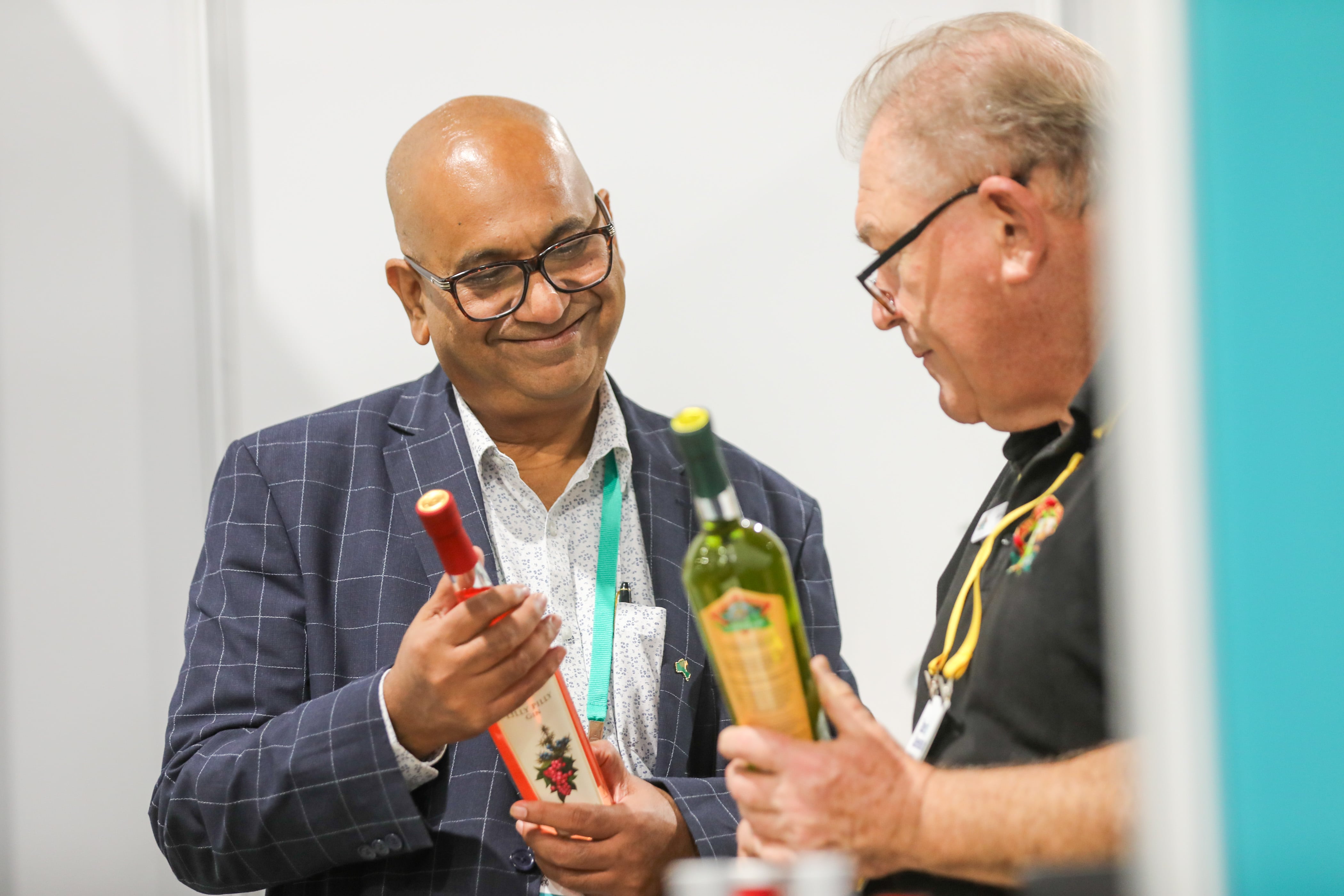 Two men talking while holding food products