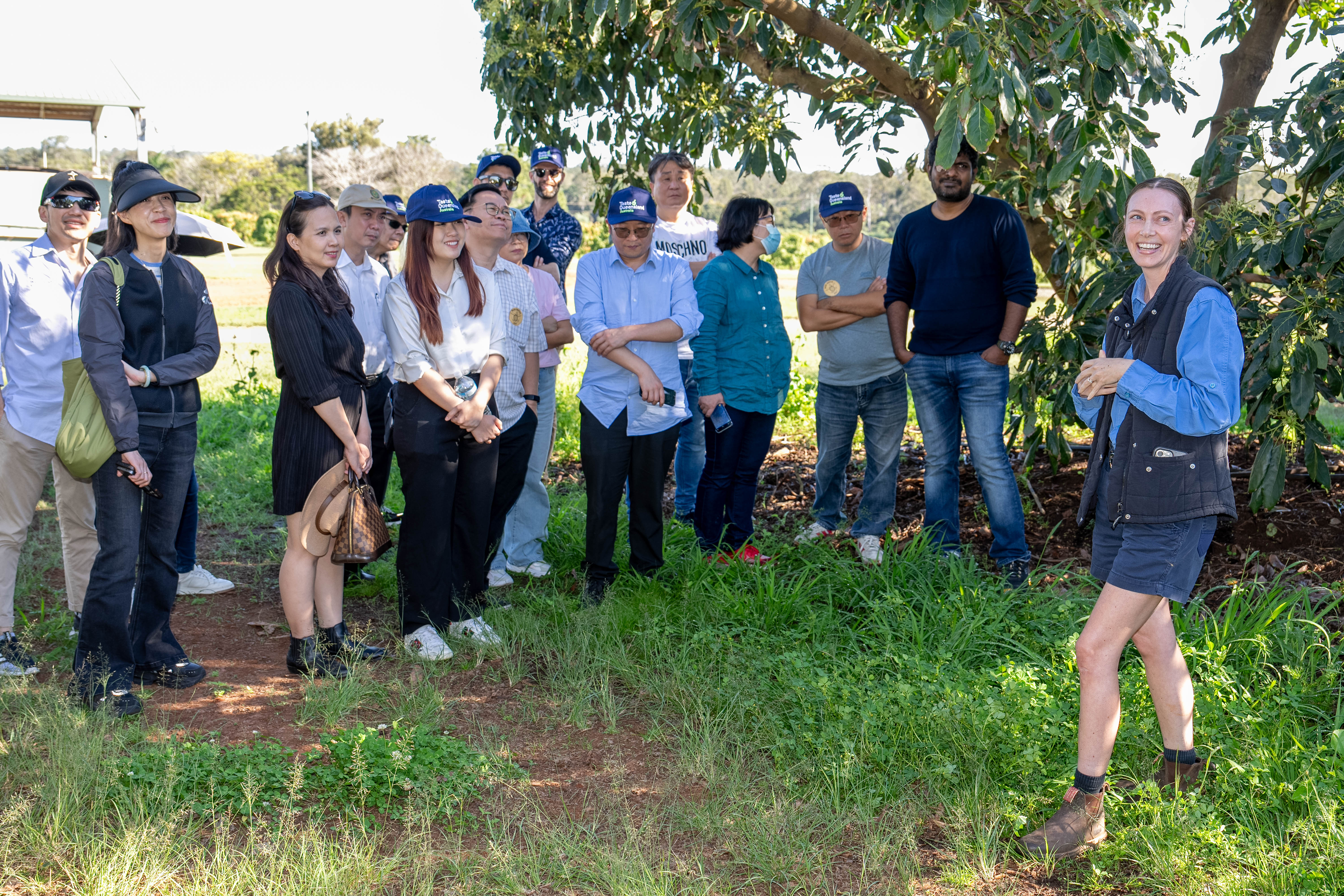 A female farmer hosting a group of international buyers on a farm.